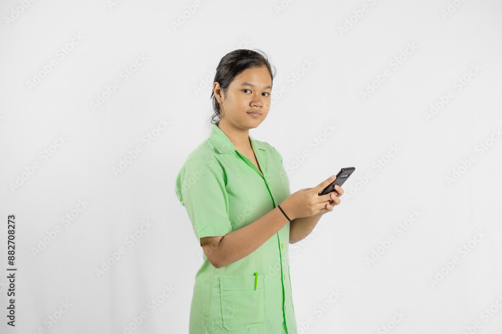 Young Asian female nurse carrying cell phone, concept of health medicine and work with full dedication, isolated white background.
Young Asian female nurse carrying cell phone, concept of health medicine and work with full dedication, isolated white background.