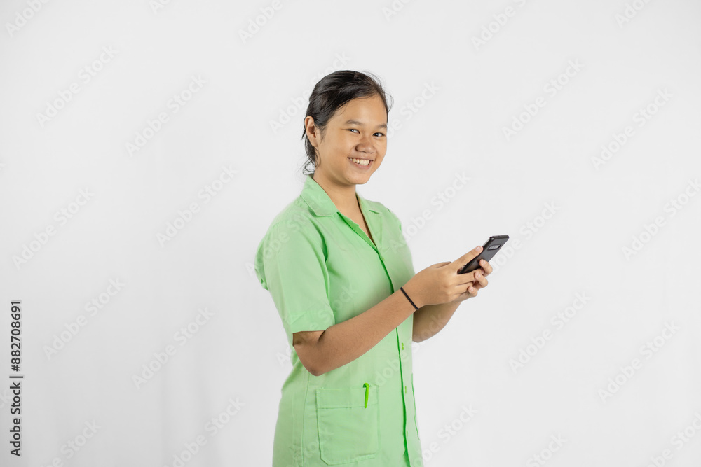 Young Asian female nurse carrying cell phone, concept of health medicine and work with full dedication, isolated white background.
Young Asian female nurse carrying cell phone, concept of health medicine and work with full dedication, isolated white background.