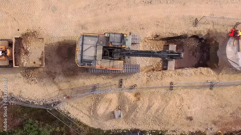 Aerial View of Excavator Digging a Trench at a Construction Site Aerial View of Excavator Digging a Trench at a Construction Site