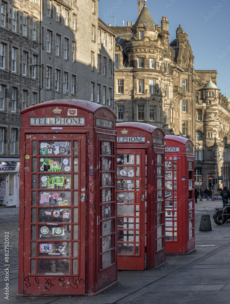 Three red Telephone Boxes in row on the Royal Mile. Iconic traditional red british phone boxes, Classic red telephone cabinet, Space for text, Selective focus.