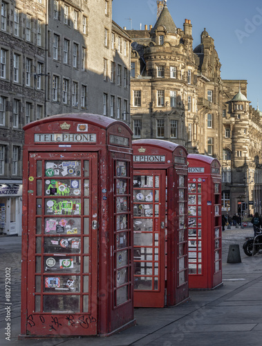Obraz na płótnie Three red Telephone Boxes in row on the Royal Mile. Iconic traditional red british phone boxes, Classic red telephone cabinet, Space for text, Selective focus. w salonie