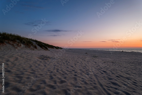 Fototapeta Naklejka Na Ścianę i Meble -  A beautiful, wide beach on the Baltic Sea. Blue hour. The sky is hot. Dunes covered with seaside vegetation. Slajszewo, Poland