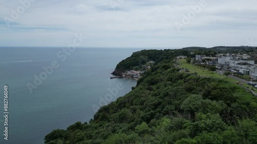 Babbacombe, South Devon, England: DRONE VIEWS: The drone flies alongside Babbacombe Downs towards Babbacombe beach and harbour wall below. Babbacombe is a popular UK holiday destination (Clip 18). photo