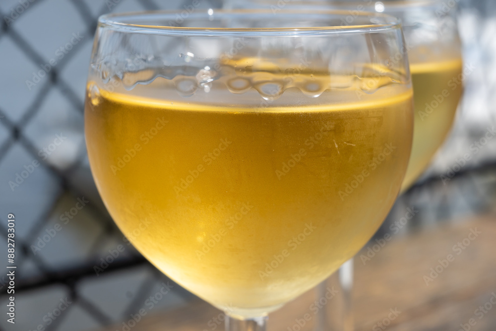 Tasting of Bordeaux white wine in Sauternes, left bank of Gironde Estuary, France. Glasses of white sweet French wine served in outdoor restaurant Tasting of Bordeaux white wine in Sauternes, left bank of Gironde Estuary, France. Glasses of white sweet French wine served in outdoor restaurant