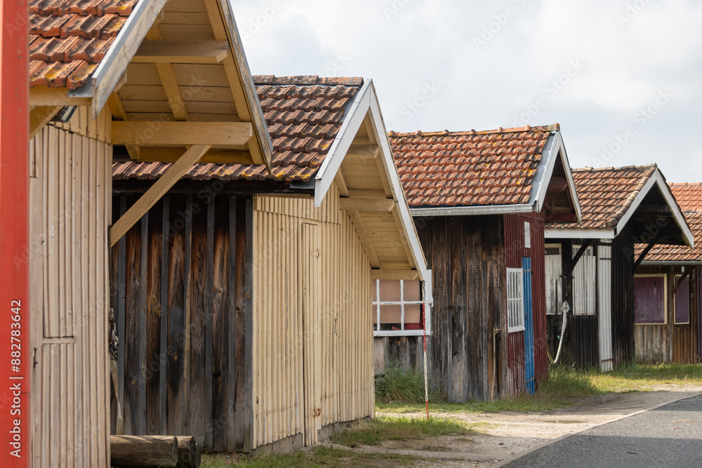 Old wooden huts and oysters farms in Port de la Hume, Gujan-Mestras village, cultivation and sale of fresh oysters seashells, Arcachon bay, Atlantic ocean, France, tourists destination Old wooden huts and oysters farms in Port de la Hume, Gujan-Mestras village, cultivation and sale of fresh oysters seashells, Arcachon bay, Atlantic ocean, France, tourists destination