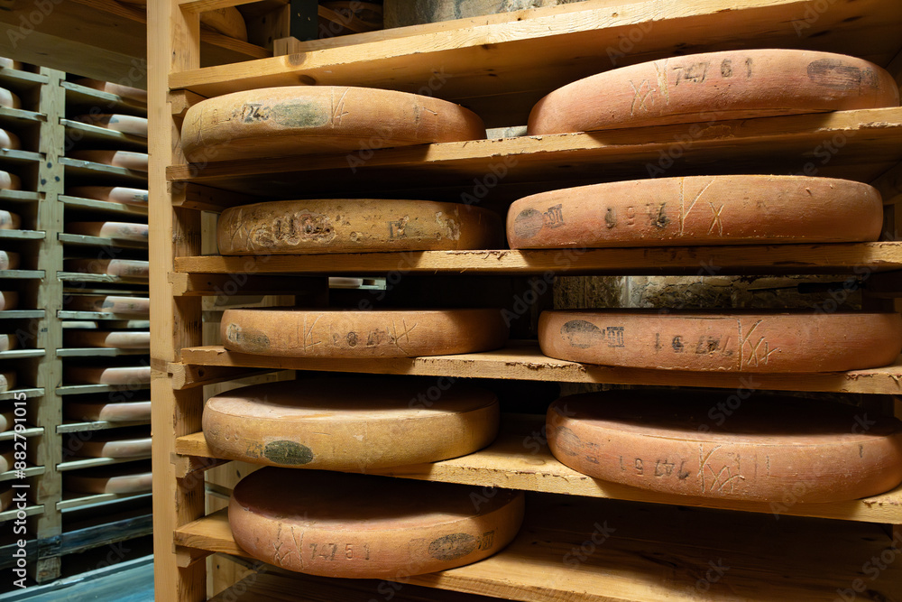 Aging rooms with shelves in cheese caves, central location for aging of wheels, rounds of Comte cheese from four months to several years made from unpasteurised cow milk, Jura, France Aging rooms with shelves in cheese caves, central location for aging of wheels, rounds of Comte cheese from four months to several years made from unpasteurised cow milk, Jura, France