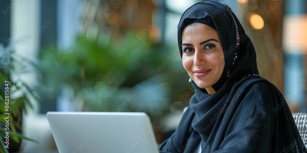 Smiling Woman in a Black Hijab with a Laptop Smiling Woman in a Black Hijab with a Laptop
