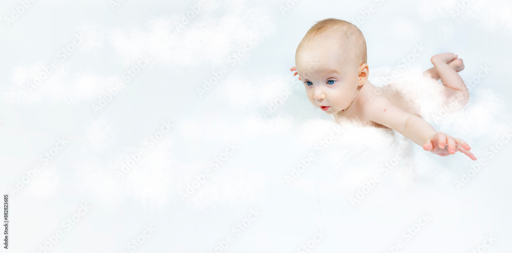 a baby with a hemangioma on his neck lies on a white background. banner with a copy space. pspread arms. the concept of flight