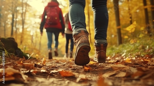 Group of tourists walks along the path of the autumn forest. Feet close-up. Traveling in a small group.