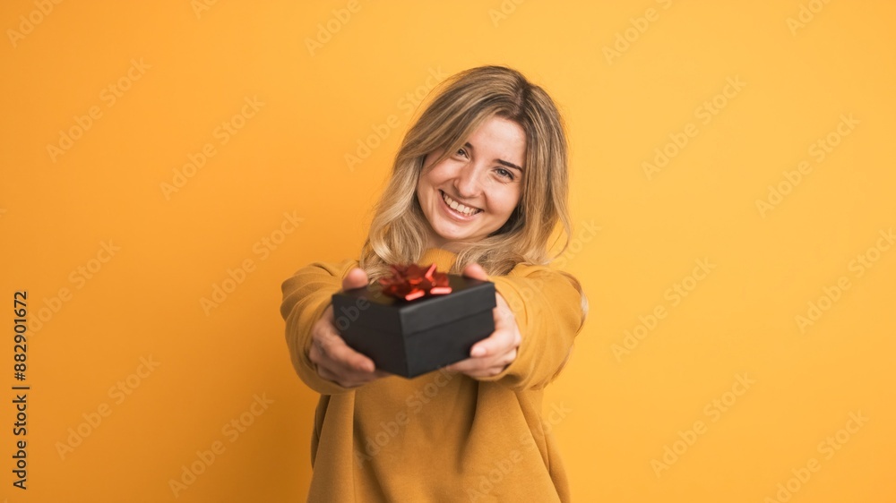Happy young woman receiving gift box and saying thanks on yellow background Happy young woman receiving gift box and saying thanks on yellow background