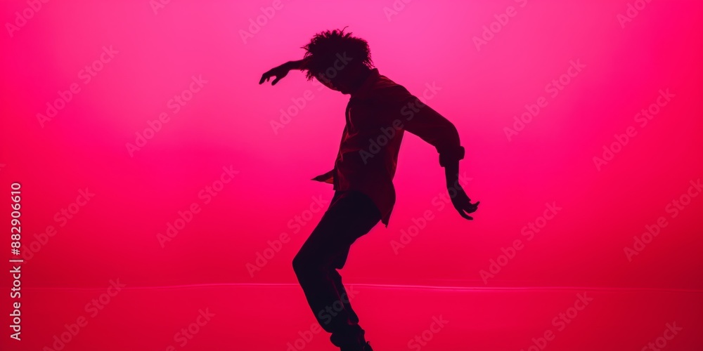 Silhouette of a young model man posing in a neon-lit studio, showcasing modern grace and flexibility in a contemporary dance pose. Silhouette of a young model man posing in a neon-lit studio, showcasing modern grace and flexibility in a contemporary dance pose.