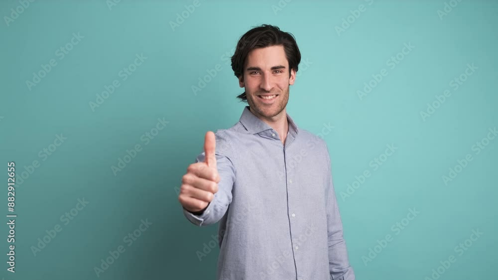 Happy man showing thumbs up in blue studio Happy man showing thumbs up in blue studio