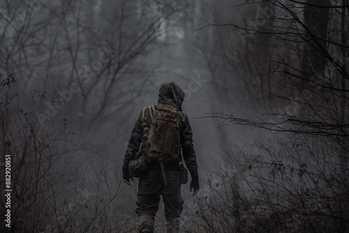Foto A man in camouflage in a post-apocalyptic smoky dark forest