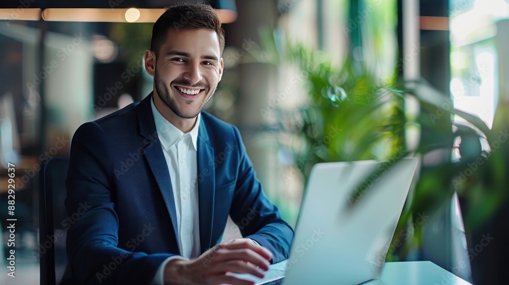 Portrait of happy businessman sitting with laptop in his office Portrait of happy businessman sitting with laptop in his office