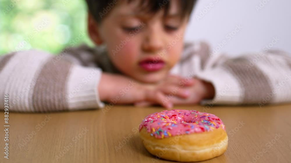 A young boy leaning on a table, gazing thoughtfully at a colorful sprinkled donut, embodying the concept of delayed gratification and temptation with a curious and contemplative expression A young boy leaning on a table, gazing thoughtfully at a colorful sprinkled donut, embodying the concept of delayed gratification and temptation with a curious and contemplative expression