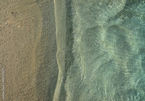 Fototapeta Naklejka Na Ścianę i Meble -  Top view of clear shallow water with sunlight reflections on a sandy beach in Ellaidhoo, Maldives