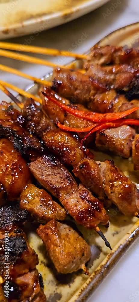 Beef satay marinated with spice and sweet soy sauce, local called satay Maranggi coriander beef satay, served on plate with onion, chilli, soy sauce and tomato. Indonesian food, sstkVertical Beef satay marinated with spice and sweet soy sauce, local called satay Maranggi coriander beef satay, served on plate with onion, chilli, soy sauce and tomato. Indonesian food, sstkVertical