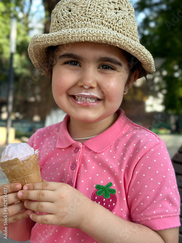 Portrait of a cute brunette girl with ice cream on a walk in the park. 