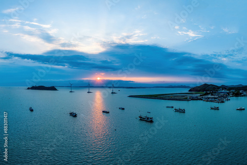 Aerial and sunset view of fishing boats moored on the sea against wind generators at Tando Port near Danwon-gu of Hwaseong-si, South Korea 