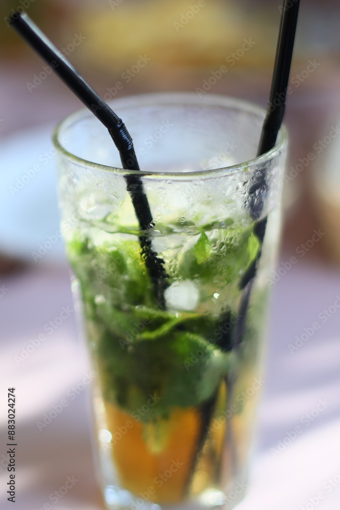 A close-up shot of a glass filled with water and featuring a straw for drinking.