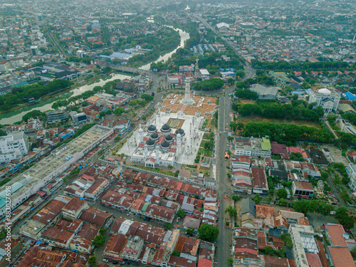 Aerial drone view of big city scenery with Masjid Raya Baiturrahman in Banda Aceh, Aceh, Indonesia. photo