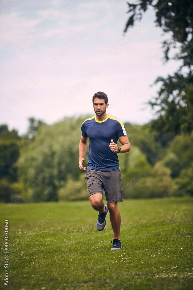Morning, fitness and man on grass for running challenge, wellness and healthy outdoor exercise. Training, cardio and runner in park in nature with commitment, progress and athlete in muscle workout. Morning, fitness and man on grass for running challenge, wellness and healthy outdoor exercise. Training, cardio and runner in park in nature with commitment, progress and athlete in muscle workout.