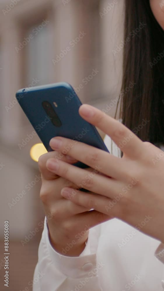 Vertical Screen: Business woman using smart phone outside workplace. Portrait of pretty girl reading funny message on mobile Vertical Screen: Business woman using smart phone outside workplace. Portrait of pretty girl reading funny message on mobile