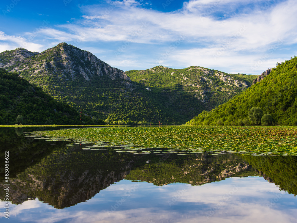 Beautiful water landscape on Lake Skadar with reflection of mountains in the water Beautiful water landscape on Lake Skadar with reflection of mountains in the water