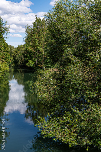 Die Innerste fließt ruhig zwischen den Bäumen dahin,Im Fluss spiegeln sich Wolken und auch einige Bäume