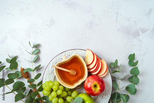 Jewish holiday Rosh Hashana concept with honey, apple and grapes on bright background. Top view, flat lay photo