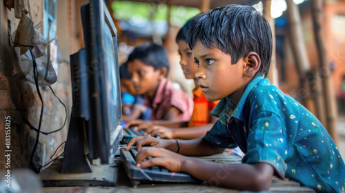 Young boys focused on learning computers in an outdoor classroom setting in a rural area photo