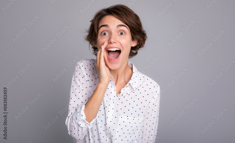 Portrait of beautiful young woman in smart casual wear is shouting or gossiping isolated on grey color background studio. Portrait of beautiful young woman in smart casual wear is shouting or gossiping isolated on grey color background studio.