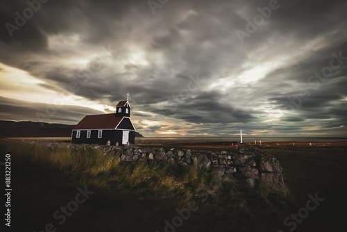 Long exposure of Saurbæjarkirkja at the Icelandic west fjords around midnight under cloudy skies and storm.