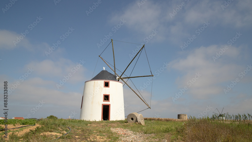 Old restored windmill in Aljezur, Portugal, against the blue sky Old restored windmill in Aljezur, Portugal, against the blue sky