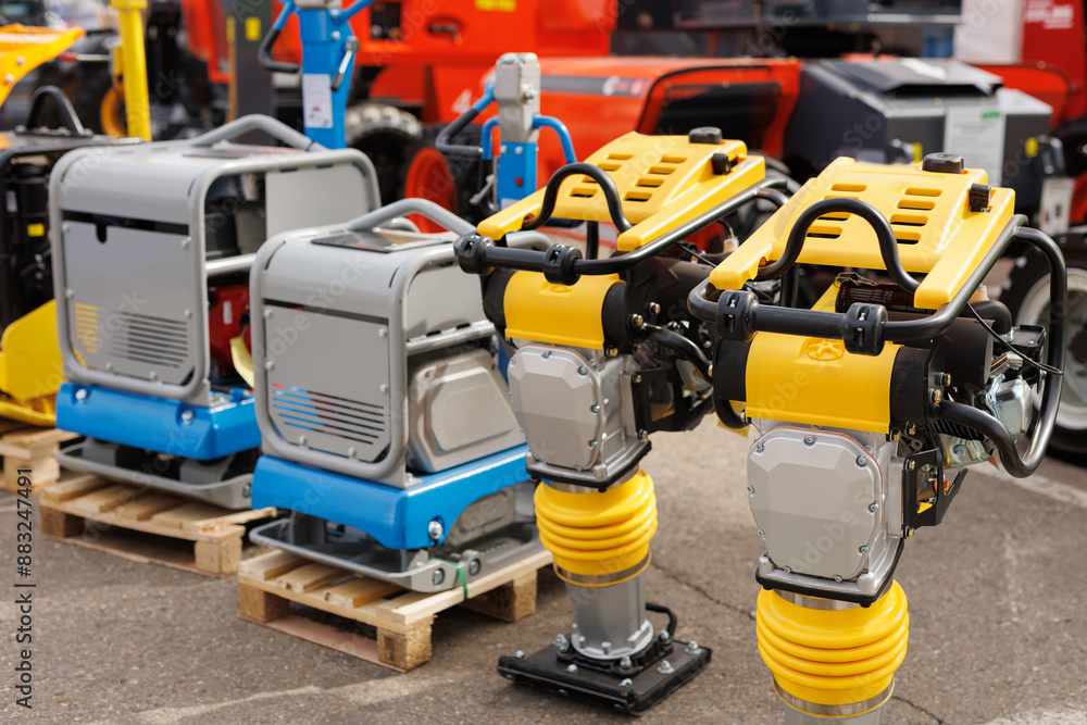 A vibrating rammer with a vibrating plate at a construction exhibition. Sale of equipment. A vibrating rammer with a vibrating plate at a construction exhibition. Sale of equipment.