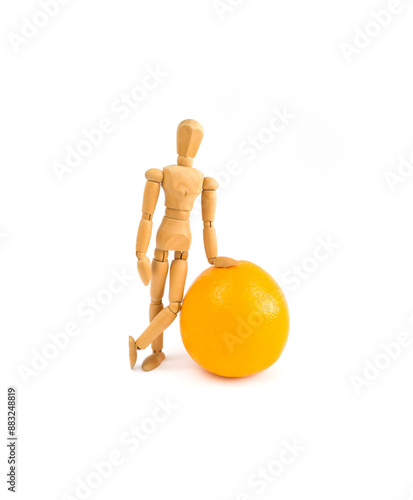 A wooden mannequin staying near the orange, Harvest concept, Isolated, White background
