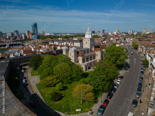 Wide aerial view of Portsmouth Cathedral surrounded by green trees next to the high street. Aerial view of the landmark and Portsmouth city skyline. Sunny summer day with blue sky.