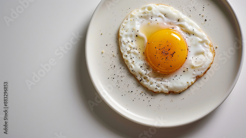 Perfectly Fried Sunny Side Up Egg on a White Plate