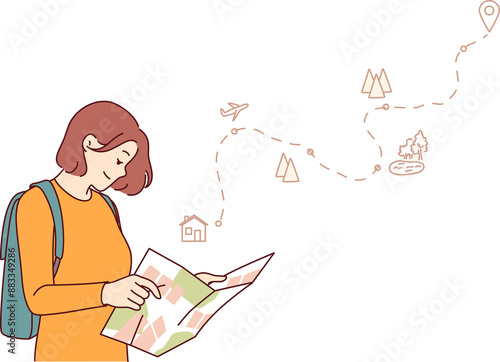 Woman tourist uses paper map to travel through nature reserves and plot route to destination. Smiling girl traveler plans tour route and chooses natural attractions worthy of visiting