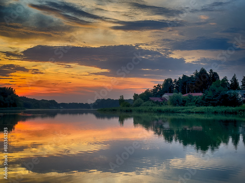 Serene Fishing Lake: A peaceful scene by the tranquil waters of a secluded fishing lake. Surrounded by lush greenery and framed by a clear blue sky, this picture captures the essence of a perfect day 