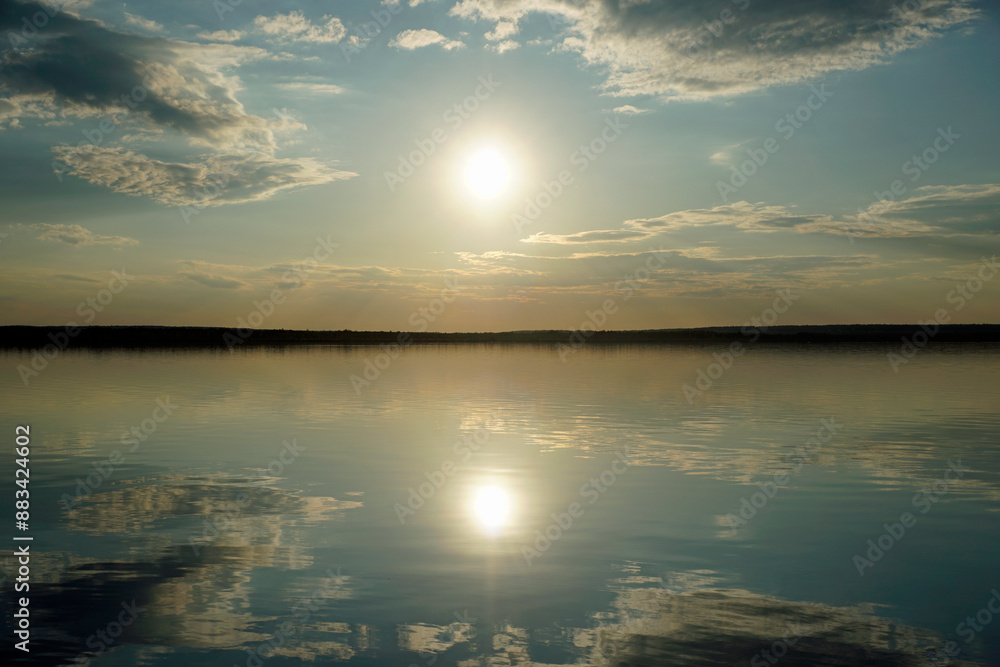 Quiet evening over the lake. Bright sunset and reflection of clouds on the surface of the water. Spring . Quiet evening over the lake. Bright sunset and reflection of clouds on the surface of the water. Spring .