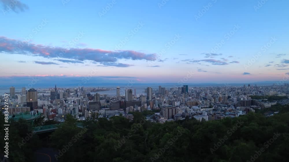 KOBE, HYOGO, JAPAN -JUN 2024 : Aerial high angle view of Kobe city and Kobe port in sunset. View of buildings and street around Kobe port tower and Sannomiya station. 4K time lapse shot, dusk to night KOBE, HYOGO, JAPAN -JUN 2024 : Aerial high angle view of Kobe city and Kobe port in sunset. View of buildings and street around Kobe port tower and Sannomiya station. 4K time lapse shot, dusk to night