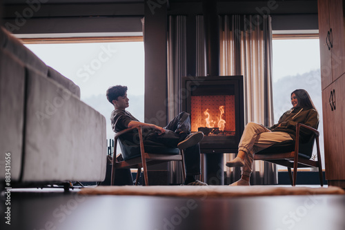 Quadro su tela Two friends enjoying each other's company in a cozy home setting with a fireplac