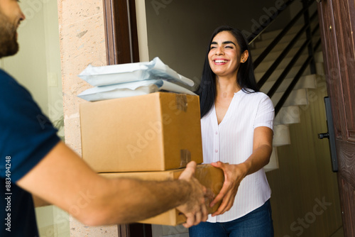 фотографія Hispanic woman accepting a pile of packages from a delivery man at her doorstep