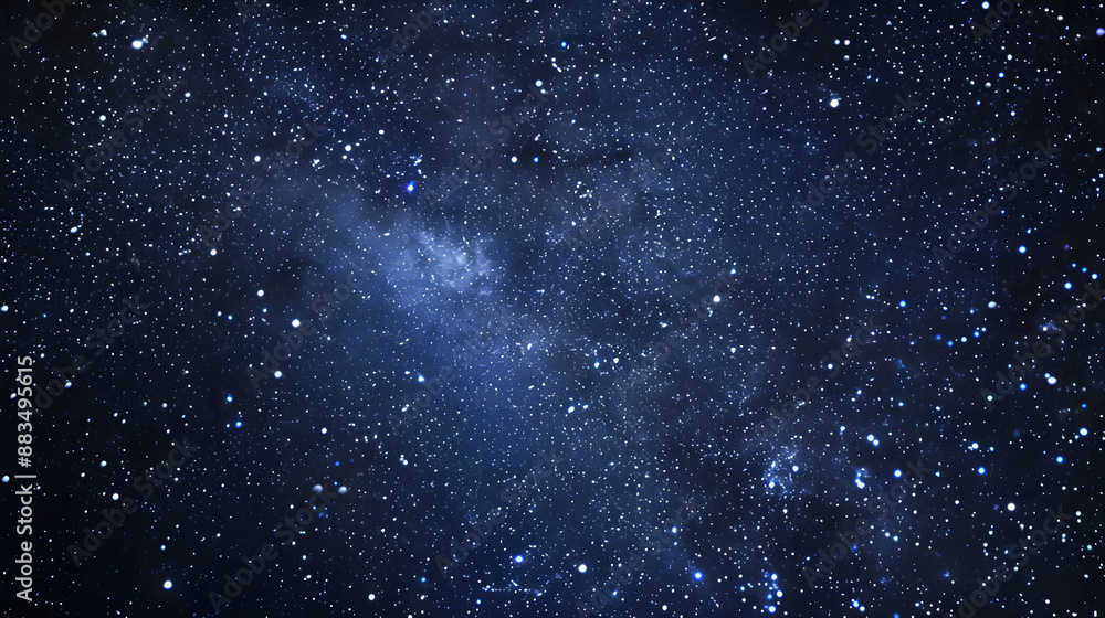 Obraz premium A panoramic view of the Milky Way galaxy at night, with dense scattering of stars across the dark blue sky.