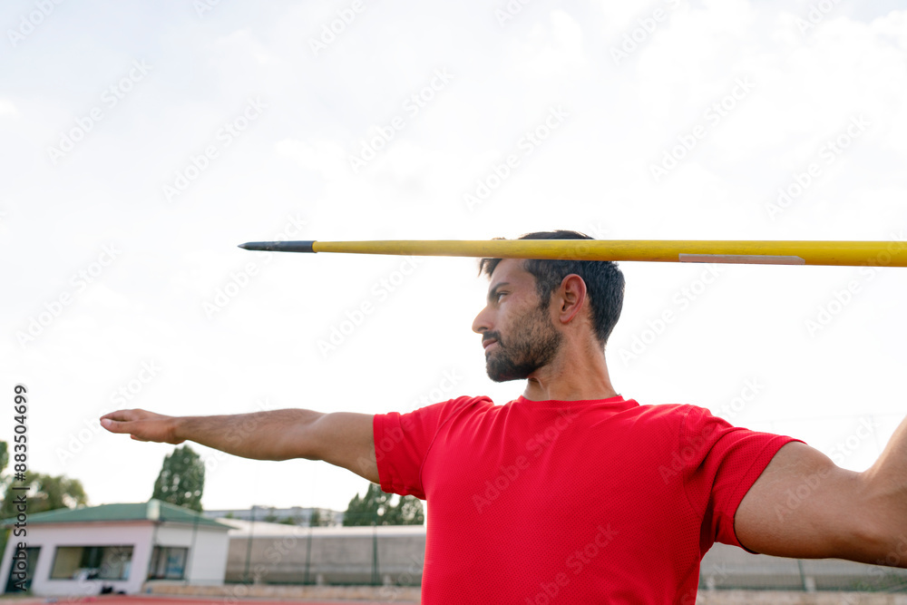 Male athlete throwing javelin at stadium