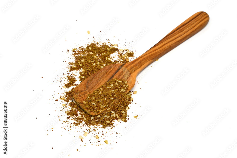 Zaatar spice in a wooden spoon isolated on white. Pile of zatar (za'atar), a middle eastern spice mix with sesame seeds, salt, oregano, thyme, and marjoram - isolated. herb spice mixture Zaatar spice in a wooden spoon isolated on white. Pile of zatar (za'atar), a middle eastern spice mix with sesame seeds, salt, oregano, thyme, and marjoram - isolated. herb spice mixture