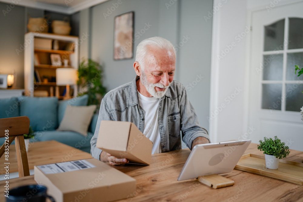 senior man sit at home hold post package delivery use digital tablet senior man sit at home hold post package delivery use digital tablet