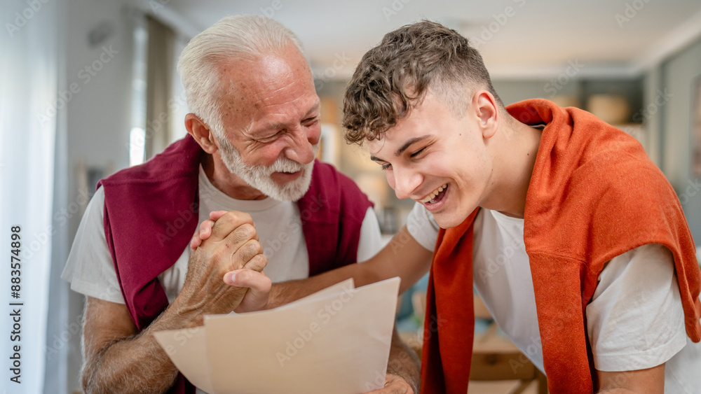 Fototapeta premium Senior man grandfather and caucasian man teenager boy grandson receive letter read good news student get scholarship or invitational letter from university share excitement real people