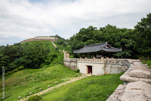 Sinhyeon-ri, Mungyeong-si, Gyeongsangbuk-do, South Korea - July 22, 2023: Summer view of fortress and entrance door of Jinnammun Gate with tile house at Gomosanseong Fortress 